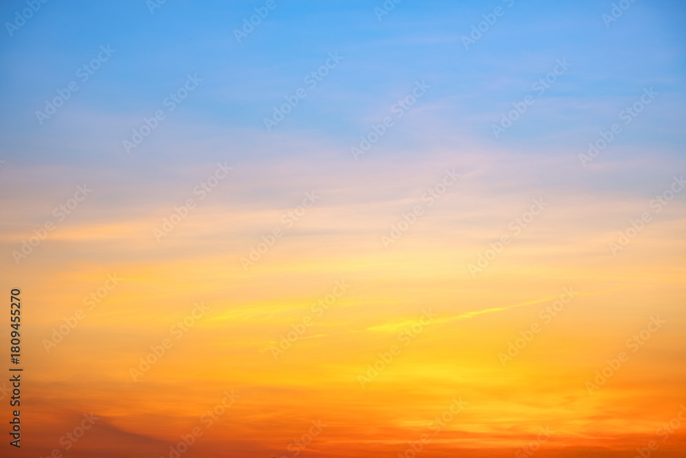 Fototapeta premium Sunset or sunrise sky with a vibrant gradient of orange, gold, and soft blue. Clear atmosphere with wispy clouds. Peaceful, natural light background. hope, freedom, new day and inspirational Concepts