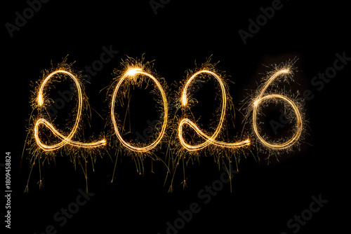 Happy New Year 2026. Burning sparkling text 2026 isolated on black background.