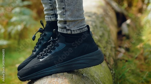 Unrecognizable person stepping on log in forest connecting with nature and travel harmony. Person walking through woods promoting outdoor relaxation and sustainable tourism. Individual going over