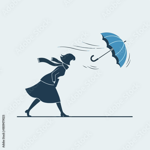 Woman walking in wind on a windy day, a silhouette of female with scarf in gale force weather, holding onto her blue umbrella against storm.