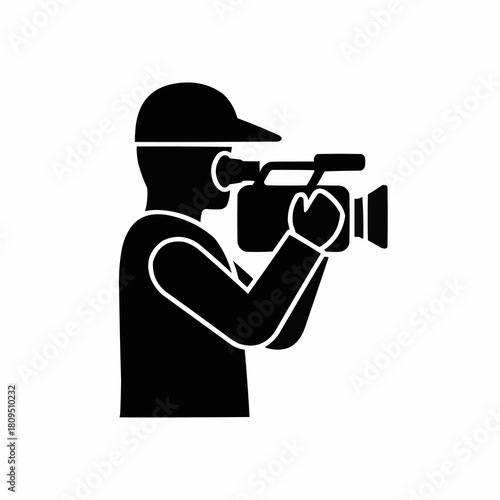 Silhouette of a person holding a video camera filming.