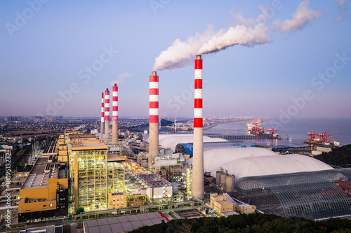 Wallpaper Mural Aerial view of a large thermal power plant with smoking chimneys by the coastal industrial port at dusk Torontodigital.ca