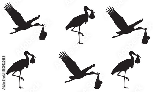 Collection of stork silhouettes carrying bundles symbolizing new life and birth announcements