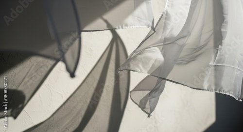 Abstract interplay of flowing white fabric and shadows on textured surface