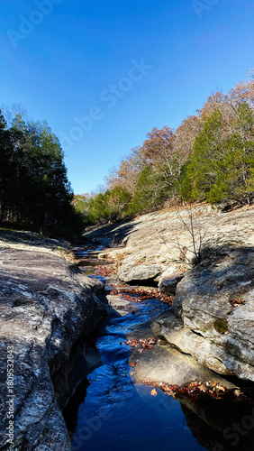 Tranquil rocky stream through Southern Illinois woodland on a clear blue sky day