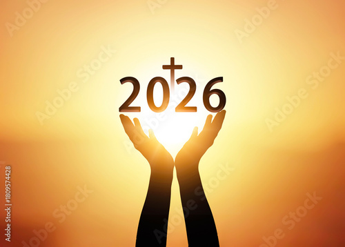Silhouette of hands holding new year 2026 on sunset background.