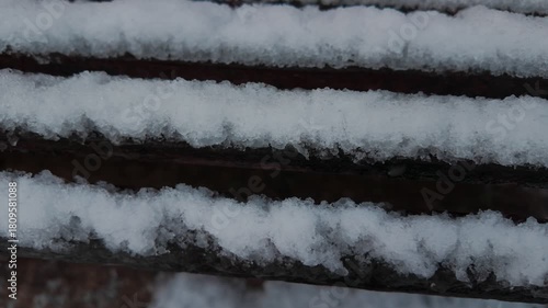 Close up snow melting on a bench. Cutaway shot.