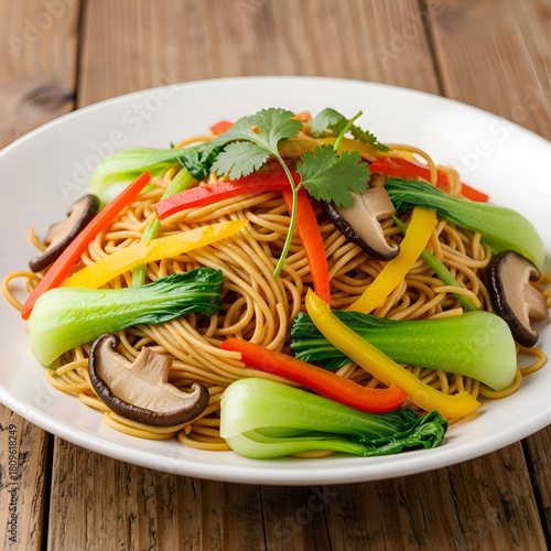 Delicious chow mein with bok choy, peppers, and mushrooms on a white plate
