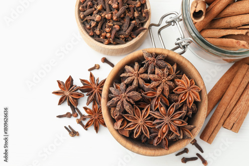 Different spices (anise, cinnamon, cloves) for mulled wine on white wooden table, flat lay