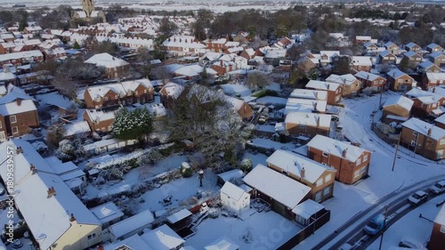 Drone 50fps. UK houses, rooftops covered in snow.  Cold Winter, Christmas season.