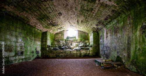 Ancient castle underground cellar of warkworth castle,, Northumberland. UK. Stone walls and cold, damp floor.