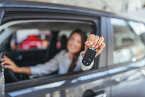Smiling Driver In Car Holding Key Fob Up For Photo Shoot