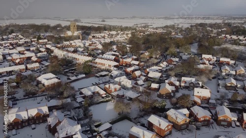 Drone 50fps. UK houses, rooftops covered in snow.  Cold Winter, Christmas season.