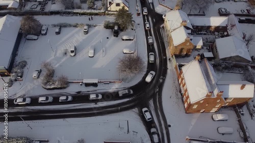 Drone. Road traffic. UK houses covered in snow. Icy winter, Christmas season.
