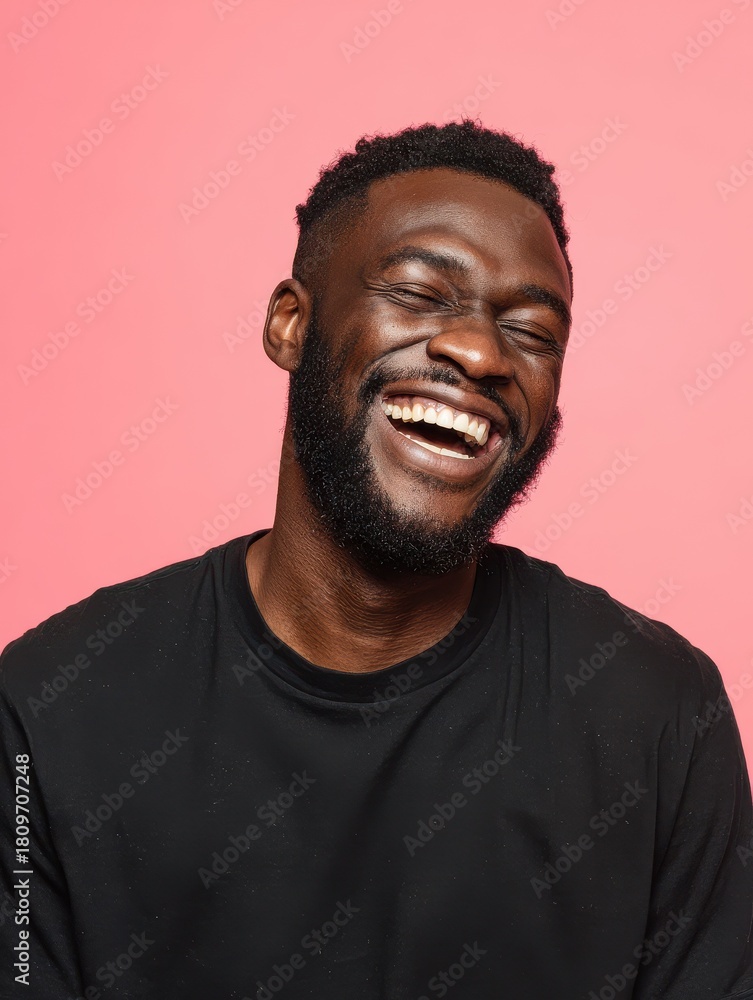 Obraz premium handsome unshaven young darkskinned male laughing out loud at funny meme he found on internet smiling broadly showing his white straight teeth positive human facial expressions and emotions no logos 
