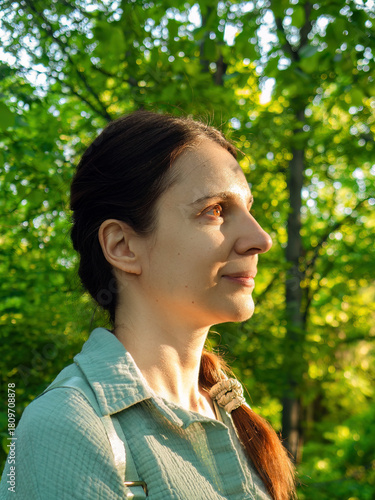 Beautiful smiling woman enjoying green nature in summer