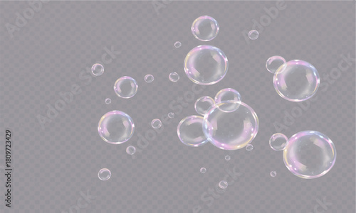 Transparent soap bubbles floating in the air on a black background with colorful light reflections