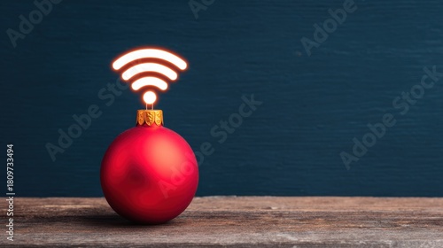 Red Christmas ornament with a glowing Wi-Fi symbol on top, placed on a wooden surface against a dark blue background.