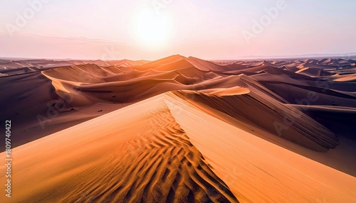 Fototapeta Naklejka Na Ścianę i Meble -  A sweeping vista of golden sand dunes stretches to the horizon, sculpted by wind and illuminated by the warm glow of the sun.