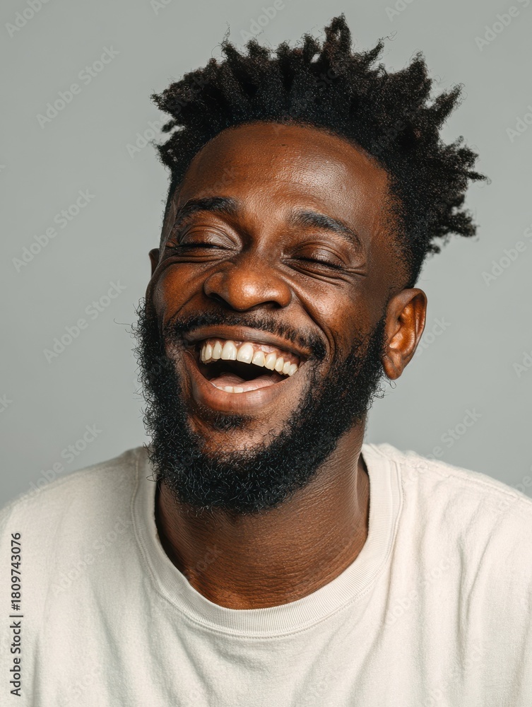 Obraz premium handsome unshaven young darkskinned male laughing out loud at funny meme he found on internet smiling broadly showing his white straight teeth positive human facial expressions and emotions no logos 