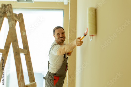 Man painting a wall in a mo...