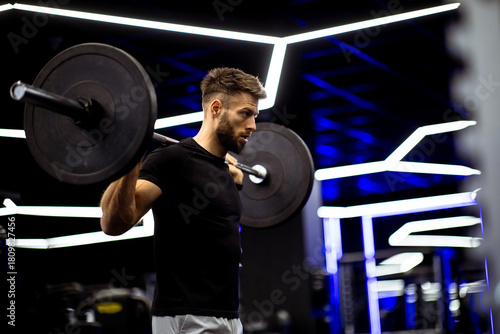 Male athlete lifts barbell ...