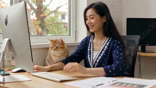 Young Asian woman working from home with her pet cat, enjoying a comfortable and productive remote work environment.