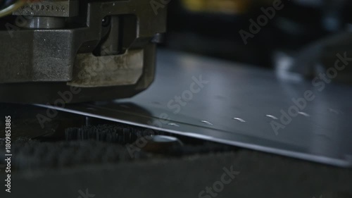 A machine punches precise holes into a metal sheet. Sparks and vibrations highlight the powerful industrial process in a workshop environment.
