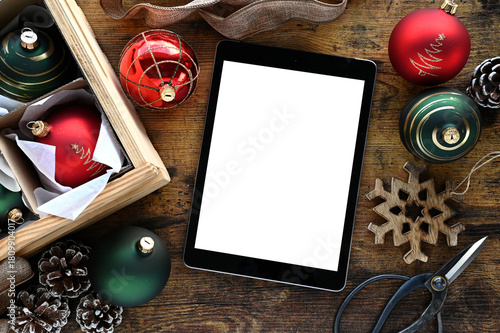 Christmas holiday decor with tablet computer blank screen; digital advertisement or website mock up