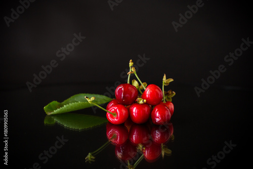 a handful of ripe red cherries on a black background