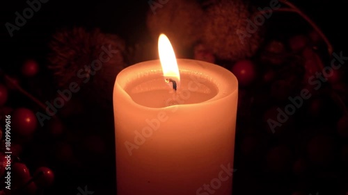 Candle burning softly in a cozy setting with warm glow and dark background