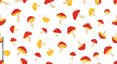 Cute and simple seamless pattern of scattered red and yellow cartoon mushrooms on a clean white background for autumn textile prints.