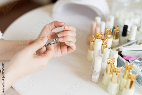 A woman is clipping her nails with nail clippers.
