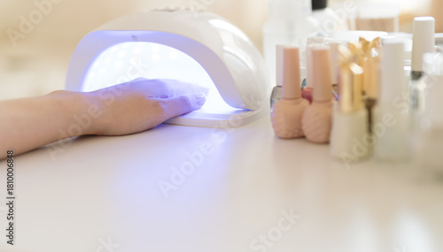 Hands with nail polish cured in a UV nail lamp