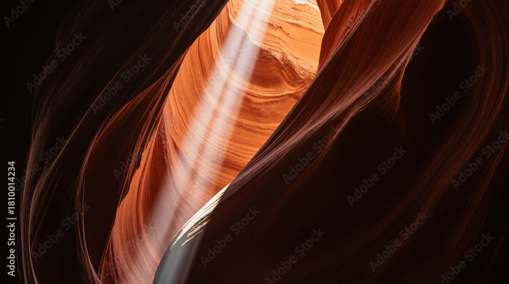 Obraz premium Interior of a dramatic crevice in a sandstone canyon with a vertical beam of sunlight.