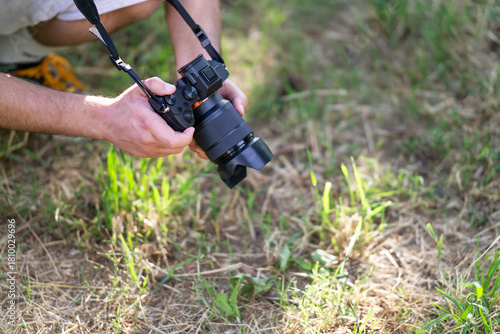 Close up of a photographer holding digital mirrorless camera 