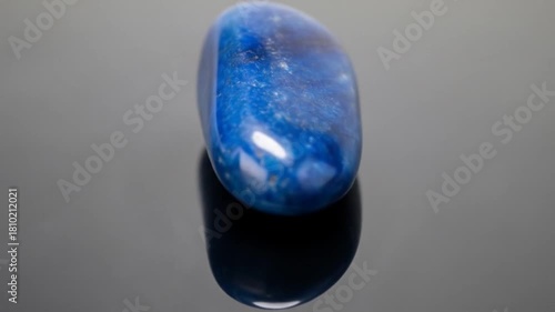 Mesmerizing Rotation of a Polished Blue Stone on a Dark Reflective Background Highlighting its