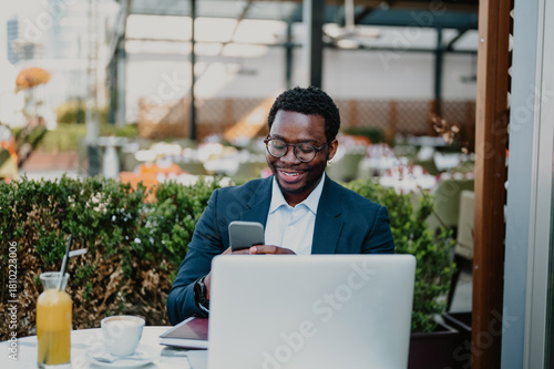 African man working with smartphone and laptop remotely