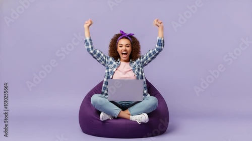 A young woman with a cheerful, excited expression, her arms raised in triumph with clenched fists