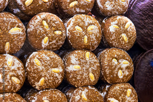 A closeup of stacked handmade german gingerbreads with almonds at a christmas market stall, showing texture, tradition, and holiday craftsmanship
