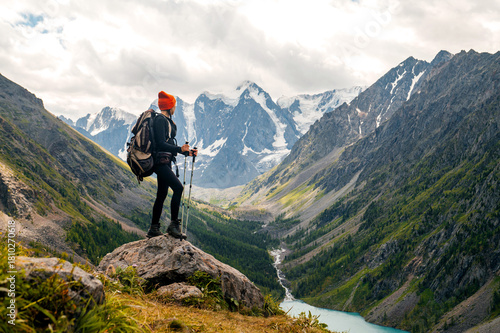 a tourist at the top of a mountain looks at the view