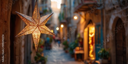 Fototapeta Naklejka Na Ścianę i Meble -  Bethlehem star decoration hangs on a lit street in a southern European town with stone buildings and holiday lights. Christmas atmosphere in a warm historic setting with festive decor.