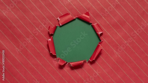 Christmas wrapping paper tears from the center on a green background. Stop motion. Layout for discounts, text, etc