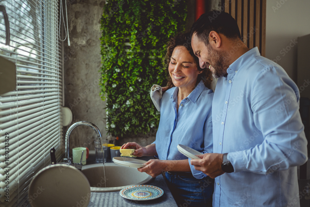 © Miljan Živković - Couple washing dishes together during daily routine
