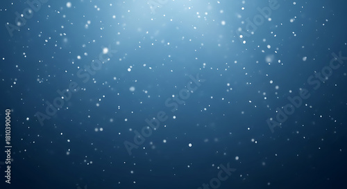Abstract blue background with shimmering particles floating in a gentle light from above.