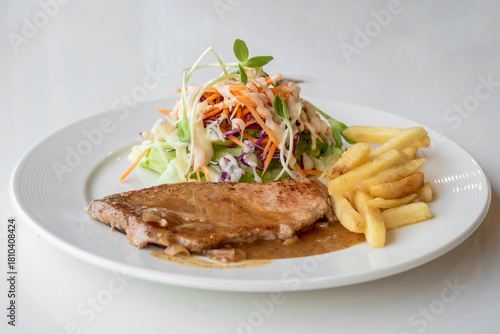 Close up of Grilled pork steak, boiled french fries and vegetable salad;Selective focus