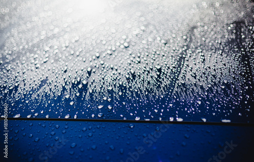 morning dew on grey car hood with water droplets close-up