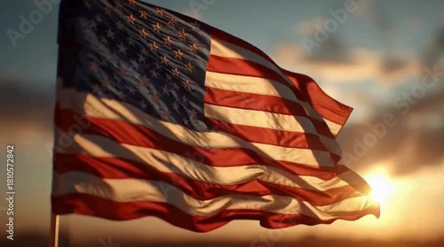 American flag waving proudly against a vibrant sunset sky with warm light.