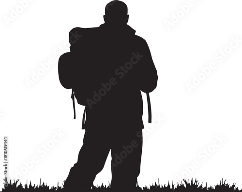 Black silhouette of a hiker with backpack standing on grass