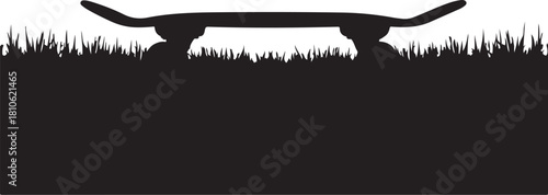 Black silhouette of a skateboard on grass wheels